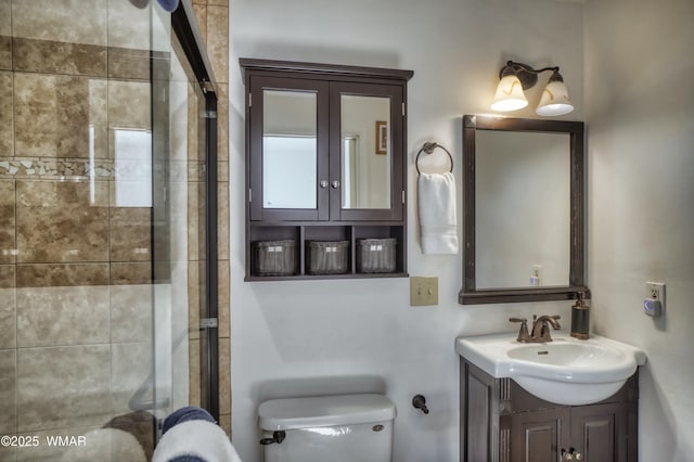 full bathroom with toilet, a shower with door, and vanity