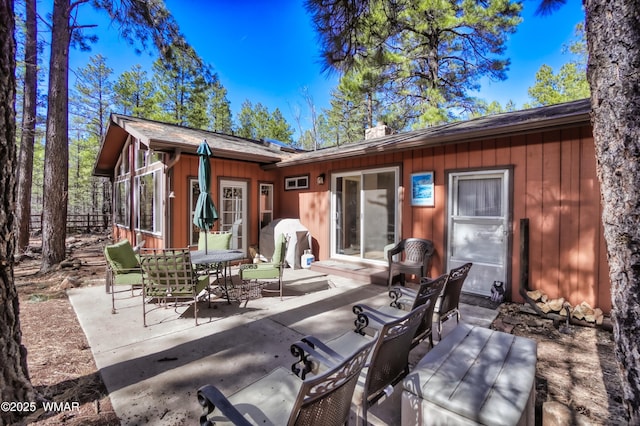 back of property featuring a patio and board and batten siding