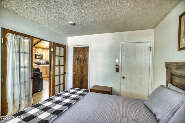 unfurnished bedroom featuring a textured ceiling, french doors, and light wood-style flooring