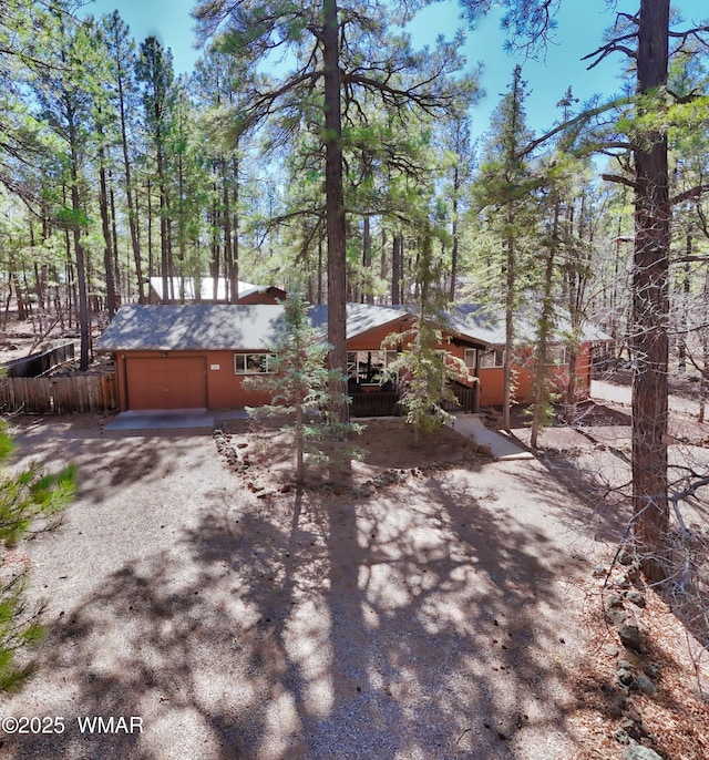 view of front of house with an attached garage and dirt driveway