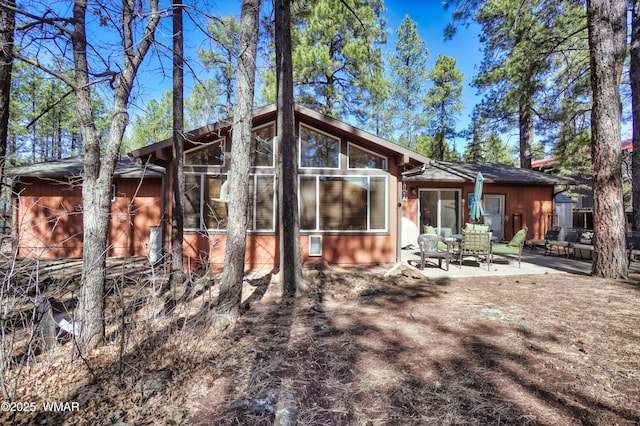 rear view of house with a patio area and a sunroom