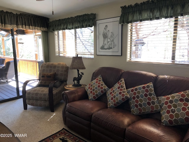 carpeted living room featuring a ceiling fan and plenty of natural light