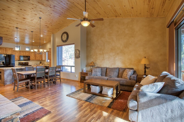 living area with ceiling fan with notable chandelier, high vaulted ceiling, wooden ceiling, and light wood-style flooring