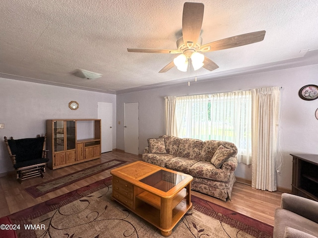 living room featuring ceiling fan, a textured ceiling, and wood finished floors