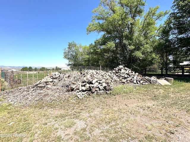 view of yard featuring a rural view and fence