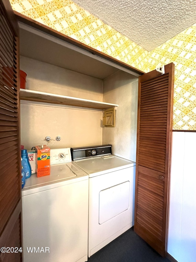 washroom featuring wallpapered walls, a textured ceiling, laundry area, and washer and dryer