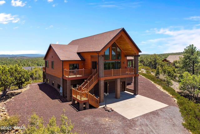 1561 S Canyon Ridge Trl, Show Low, AZ 85901 - chalet / cabin with concrete driveway, a garage, roof with shingles, stairway, and a deck