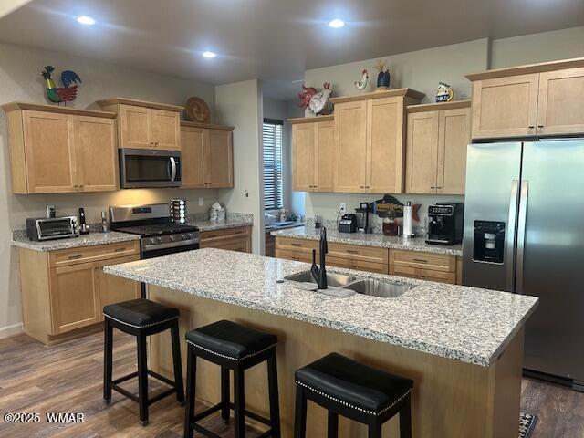 3180 N Eagles Creek Dr, Show Low, AZ 85901 - kitchen featuring appliances with stainless steel finishes, light brown cabinets, dark wood-style floors, a breakfast bar area, and recessed lighting