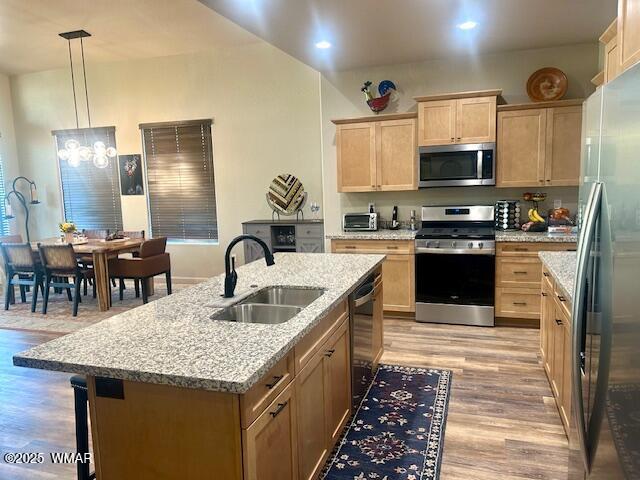 3180 N Eagles Creek Dr, Show Low, AZ 85901 - kitchen featuring appliances with stainless steel finishes, light brown cabinetry, light wood finished floors, a center island with sink, and a breakfast bar