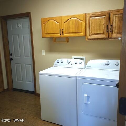 laundry area featuring washer and clothes dryer and cabinet space