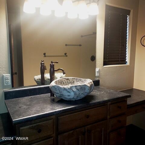 bathroom with a textured wall and vanity