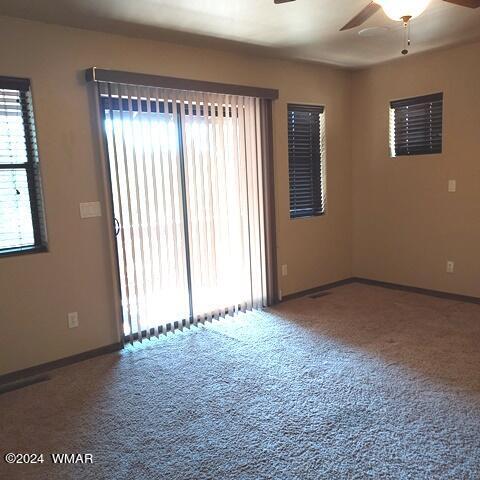 empty room featuring a ceiling fan, carpet floors, and baseboards