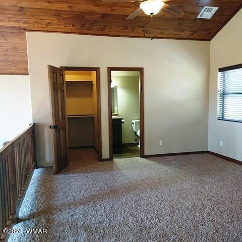 spare room featuring visible vents, baseboards, wood ceiling, ceiling fan, and dark speckled floor