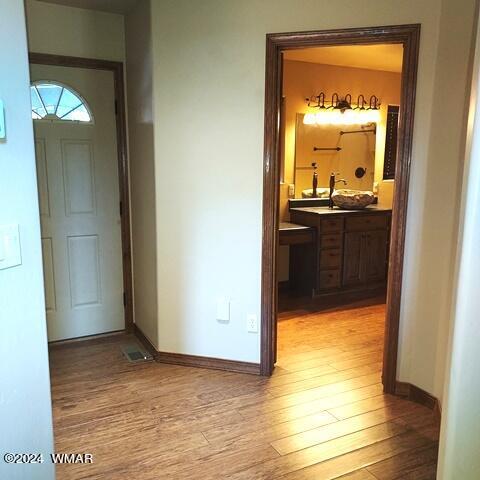 hall with light wood-type flooring and baseboards