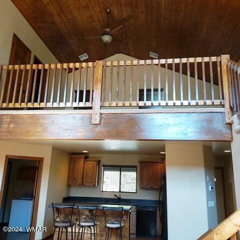 interior space with a ceiling fan, wood ceiling, brown cabinets, and black appliances