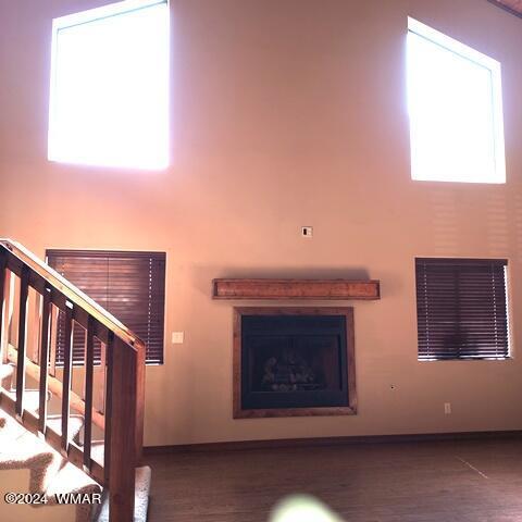 unfurnished living room with stairs, wood finished floors, and visible vents