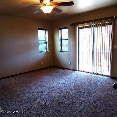 empty room featuring ceiling fan, baseboards, and carpet flooring