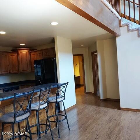 kitchen featuring freestanding refrigerator, dark wood finished floors, dark countertops, and baseboards