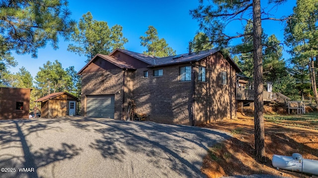 7125 Elk Trl, Show Low, AZ 85901 - view of property exterior with asphalt driveway, roof mounted solar panels, an attached garage, and a wooden deck