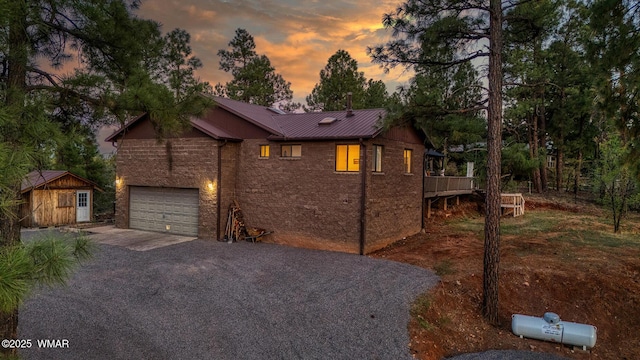 7125 Elk Trl, Show Low, AZ 85901 - view of front of property featuring driveway, brick siding, metal roof, an attached garage, and a wooden deck