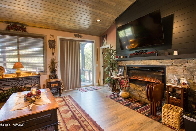 living area with wood ceiling, wood finished floors, a fireplace, and vaulted ceiling