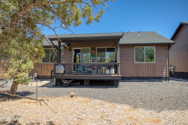 back of property with a deck and a shingled roof