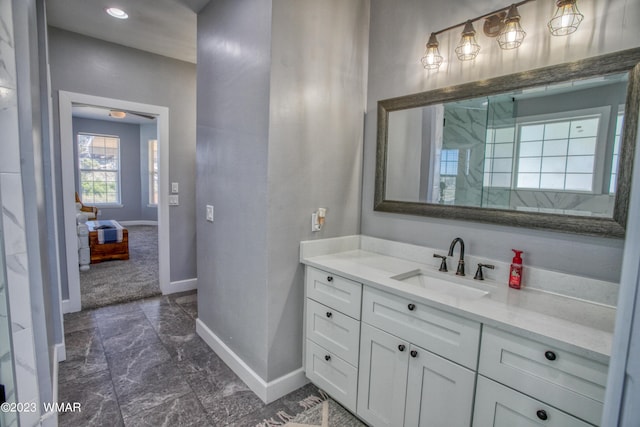 bathroom featuring baseboards, marble finish flooring, and vanity