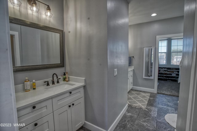 bathroom with vanity, baseboards, and recessed lighting