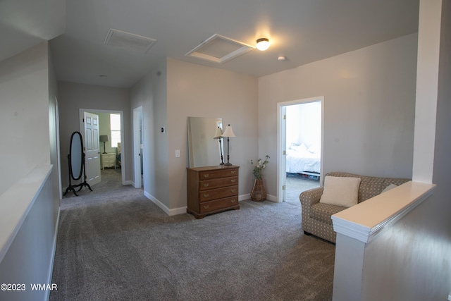 living area with attic access, carpet flooring, and baseboards