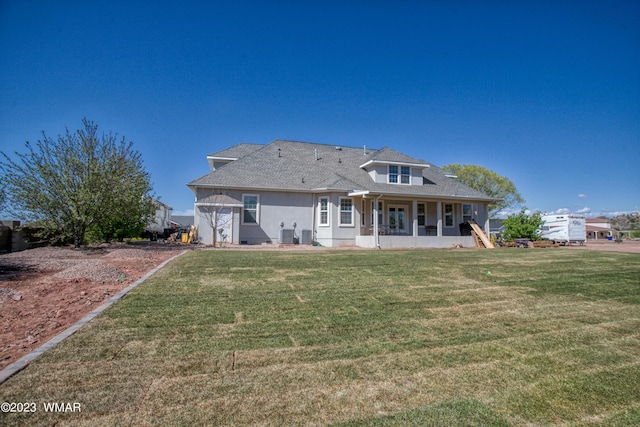 rear view of property featuring a porch and a lawn