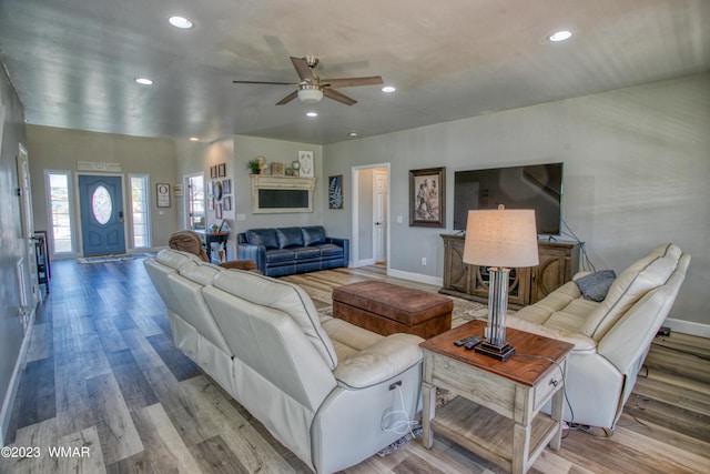 living room featuring a ceiling fan, baseboards, recessed lighting, and wood finished floors