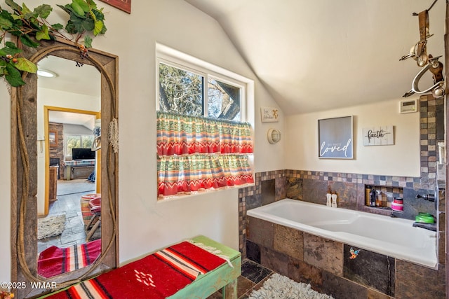 bathroom with lofted ceiling and a bath