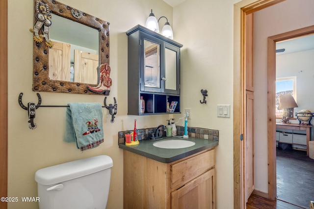 bathroom with vanity, toilet, and wood finished floors