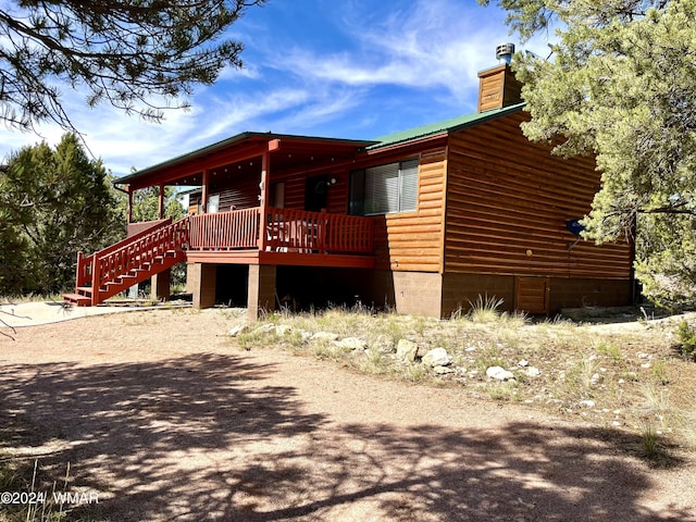 view of side of property featuring stairs and a chimney