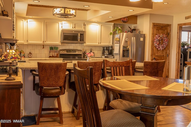 1092 Cedar Dr, Show Low, AZ 85901 - kitchen with appliances with stainless steel finishes, light wood-style floors, white cabinetry, tasteful backsplash, and recessed lighting