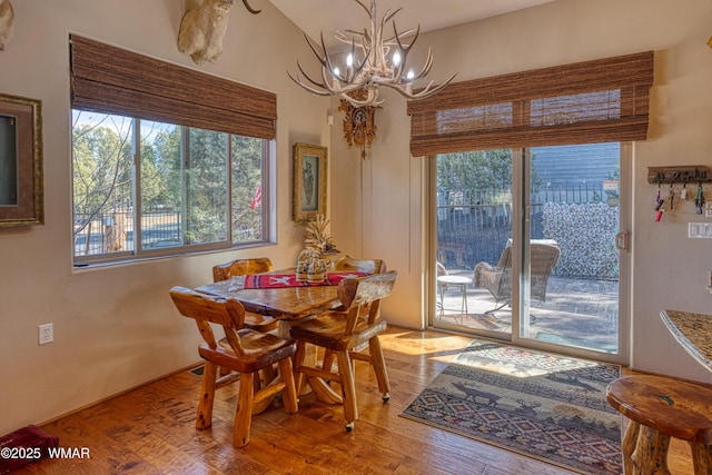 dining space featuring wood finished floors and a notable chandelier