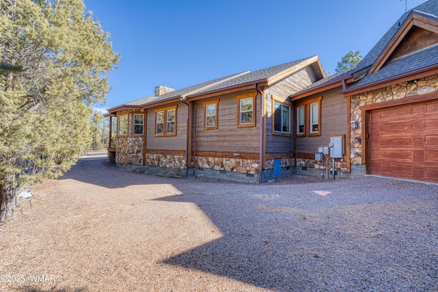 view of front of home featuring crawl space, driveway, a chimney, and an attached garage