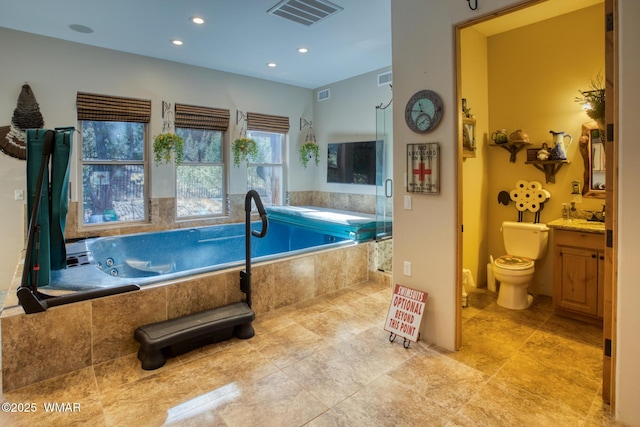 bathroom featuring visible vents, toilet, and a bath