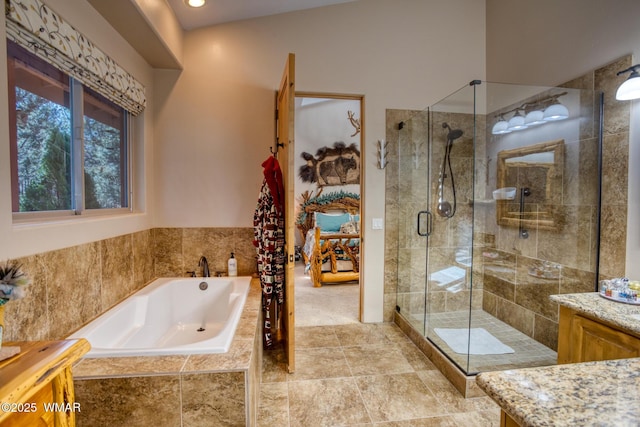 full bathroom with a stall shower, a bath, and vanity