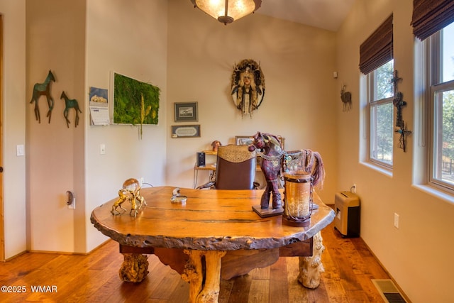 dining room featuring light wood-type flooring, visible vents, and baseboards