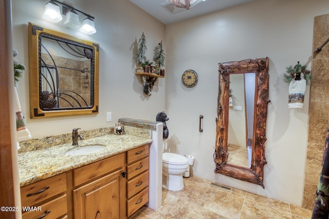 full bathroom featuring toilet, vanity, and visible vents