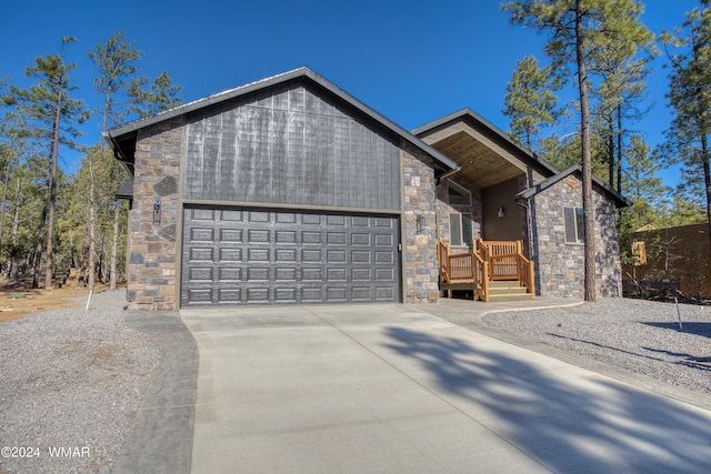 view of front of property with driveway, stone siding, and an attached garage