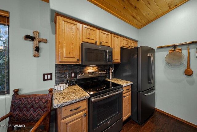 kitchen with baseboards, appliances with stainless steel finishes, backsplash, light stone countertops, and dark wood finished floors