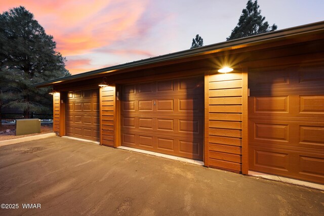 view of garage at dusk