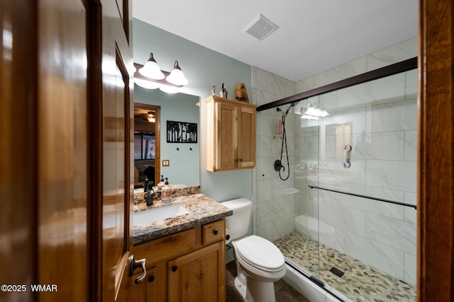 full bath with visible vents, toilet, a shower stall, and vanity