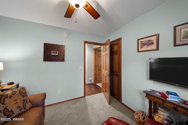 carpeted living area featuring a ceiling fan and baseboards