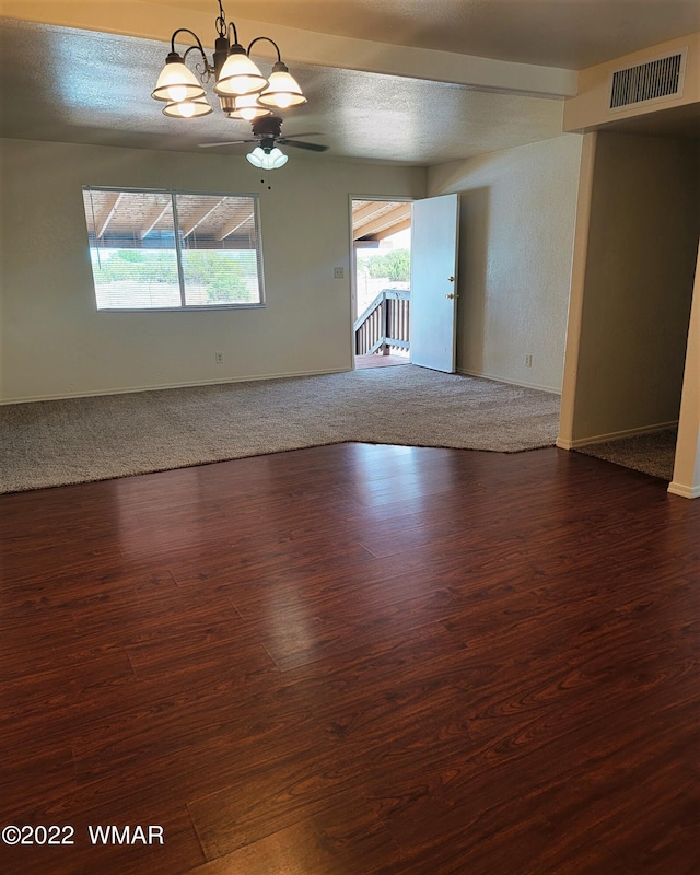 unfurnished room featuring dark wood-style floors, baseboards, visible vents, and a textured ceiling