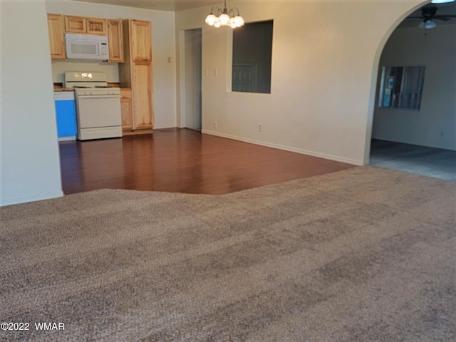 unfurnished living room with dark wood-style floors, arched walkways, dark colored carpet, and ceiling fan with notable chandelier