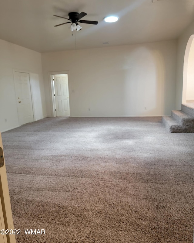 unfurnished room with carpet floors, arched walkways, ceiling fan, and recessed lighting