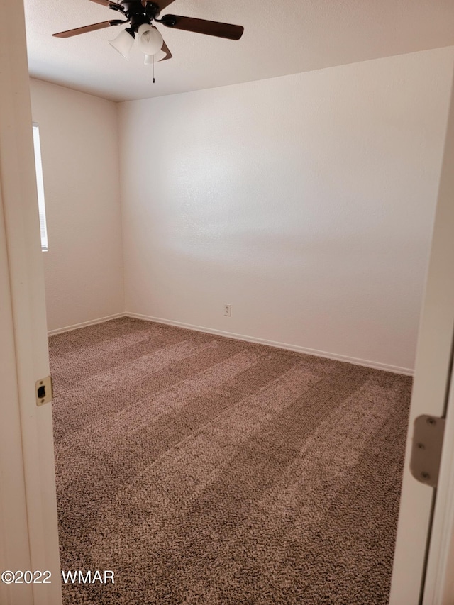 unfurnished room featuring a ceiling fan, carpet, and baseboards